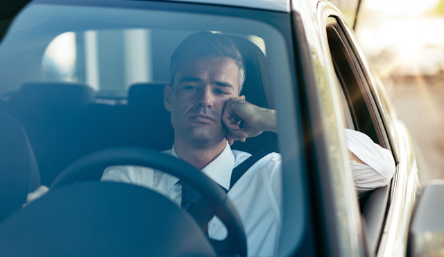 Driver waiting in car for admittance